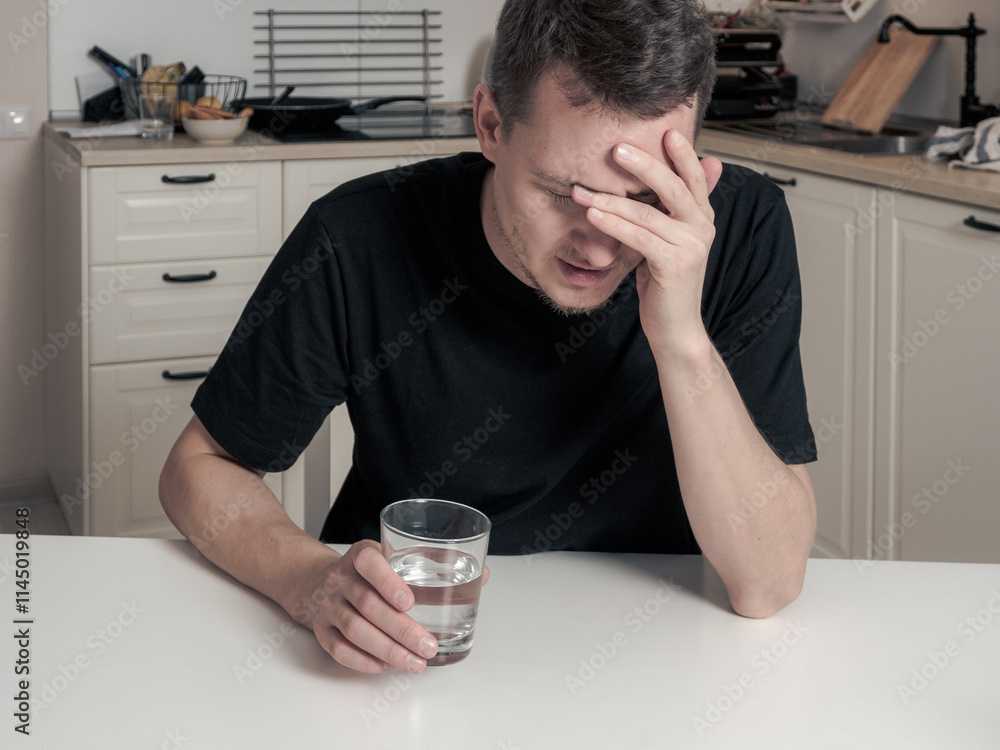 Man holding his head from a headache, a soluble pill in his other hand, preparing for relief. Man holding his head from a headache, a soluble pill in his other hand, preparing for relief.