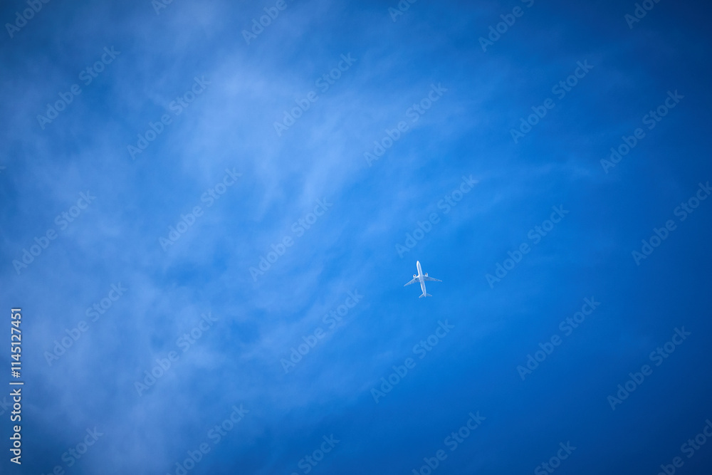 Fototapeta premium blue sky with wispy clouds and jet
