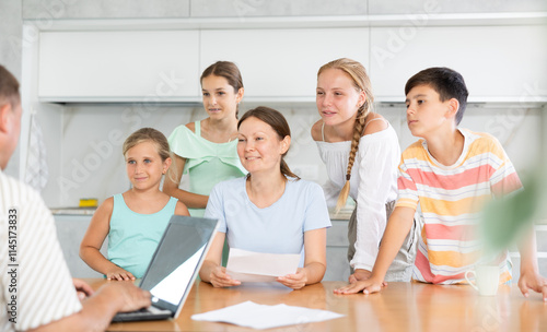 Happy mom reads letter to family and husband remotely works on laptop and listens with children to positive news, invitation, and approval of application. photo