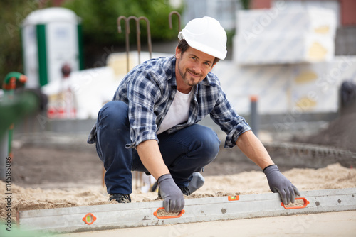 man leveling fresh cement floor with a mallet