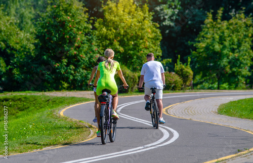 Cyclists ride on the bike path in the city Park