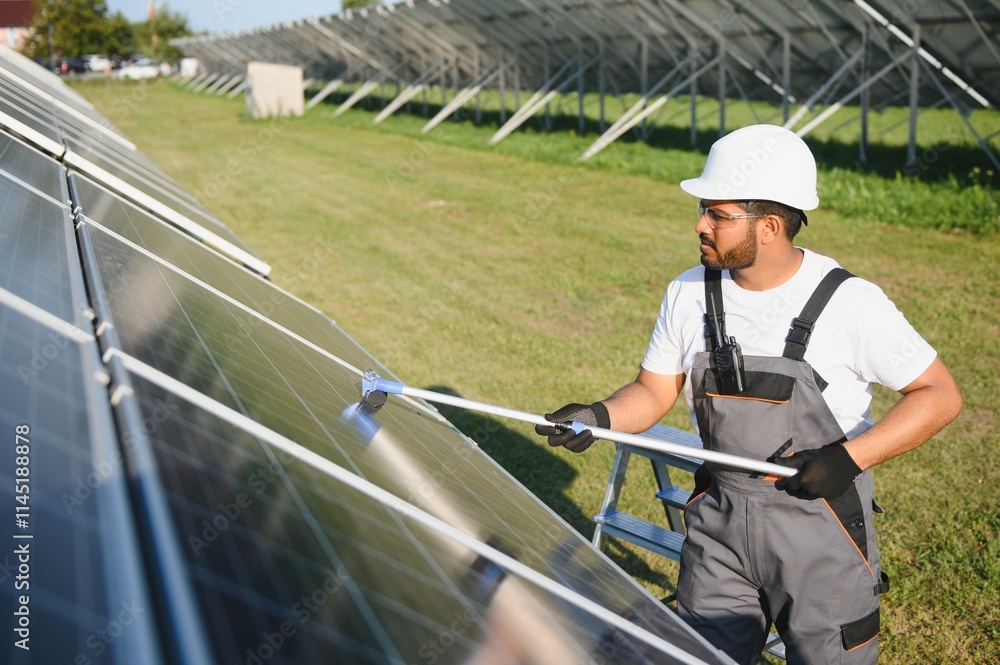 Professional indian worker cleans solar panels with brush, green electric power technology Professional indian worker cleans solar panels with brush, green electric power technology