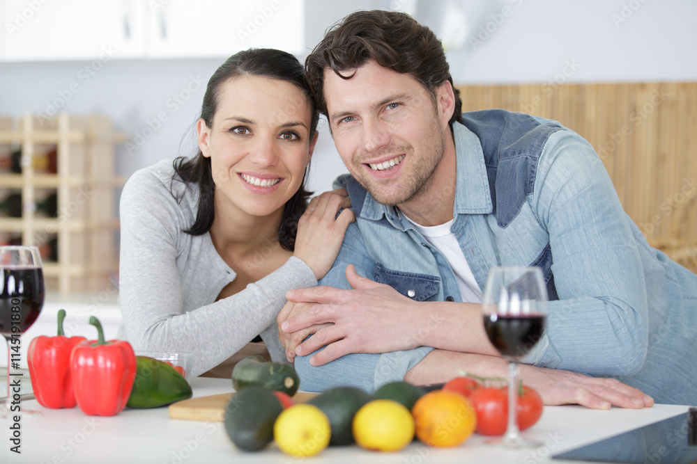 happy couple hugging and drinking red wine on the kitchen happy couple hugging and drinking red wine on the kitchen