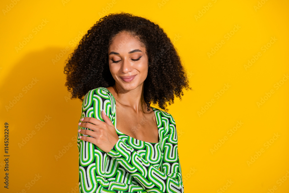 Charming young woman with curly hair embracing joy against a bright yellow background in a stylish green blouse. Charming young woman with curly hair embracing joy against a bright yellow background in a stylish green blouse.