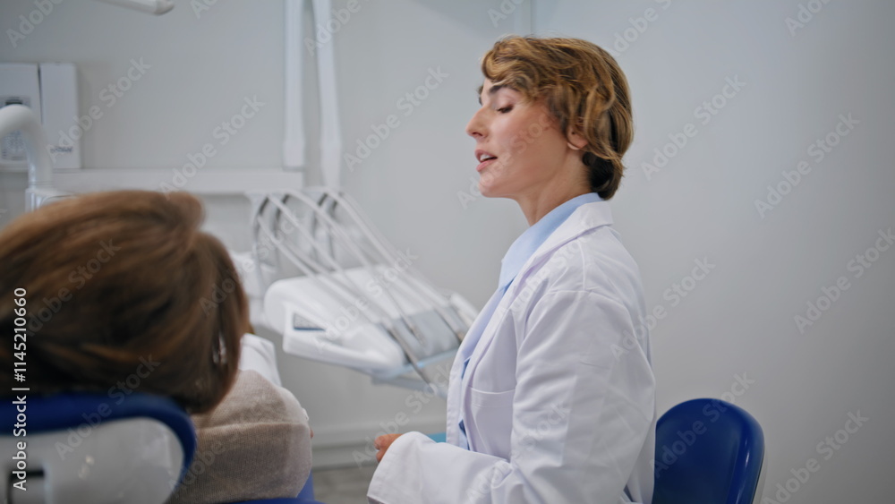 Fototapeta premium Orthodontist explaining dental procedure at examination in dentistry closeup.