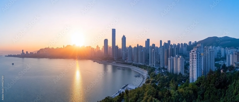 Obraz premium Panoramic view of a coastal city skyline at sunset, golden hour.