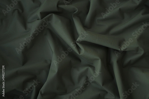 Texture of Dark green military uniform textile cloth with folds
