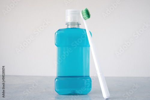 Bottle of mouthwash and plastic toothbrush on a table