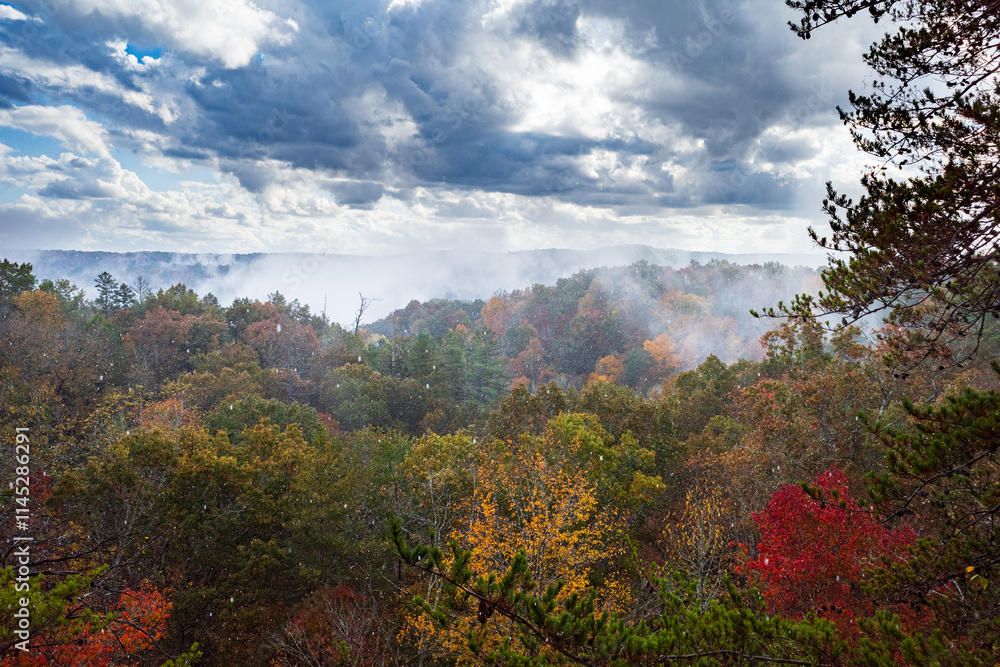 A mix of rain and snow falls over an autumn forest from an overlook in the Big South Fork National River and Recreation Area, Tennessee
