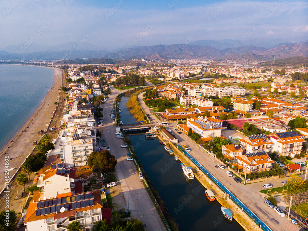 Fototapeta premium Scenic aerial view of modern cityscape of Fethiye along shoreline of Aegean Sea on sunny winter day, Turkey