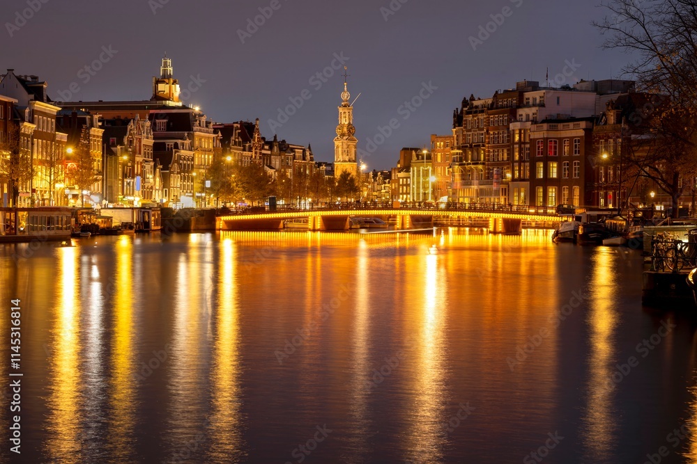 Canal in Amsterdam with illuminated buildings and reflection on the water Canal in Amsterdam with illuminated buildings and reflection on the water