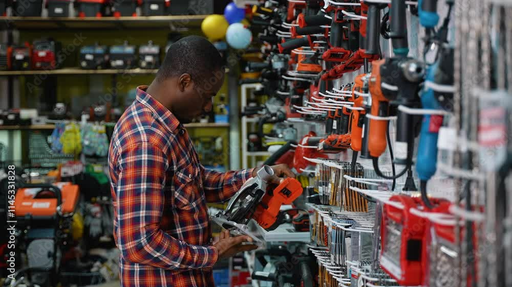African-American Man Selecting a Circular Saw in a Hardware Store African-American Man Selecting a Circular Saw in a Hardware Store