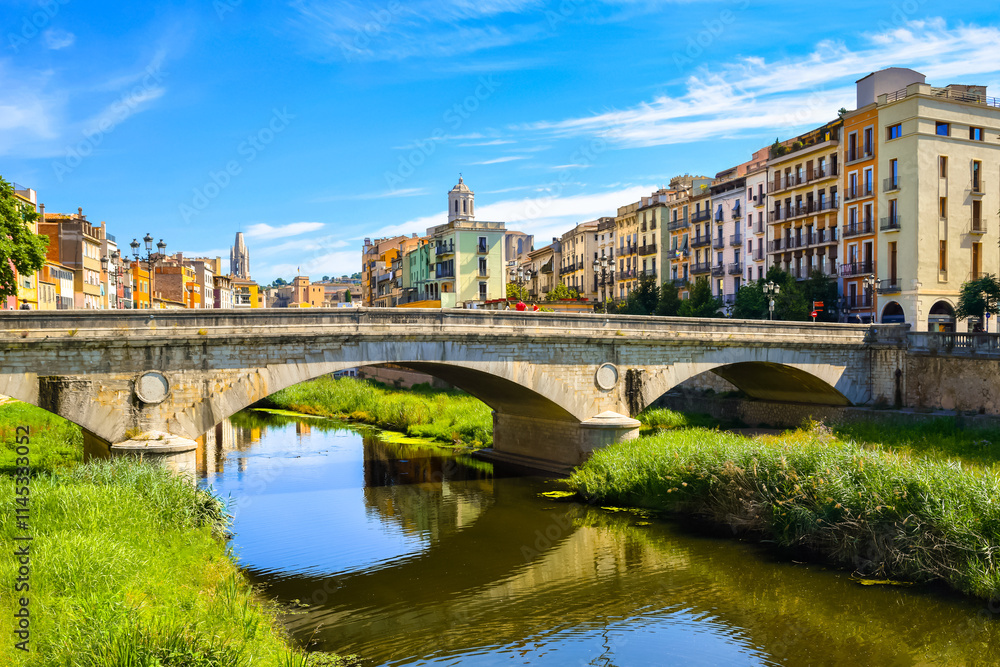 Obraz premium The stone bridge Pont de Pedra and the colorful yellow and orange houses in Girona, Catalonia, Spain.