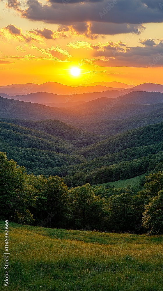 Obraz premium Misty mountains bathed in warm orange and yellow hues at sunset, symbolizing tranquility and the beauty of nature's chaos, a perfect high-definition phone wallpaper to evoke peace and awe