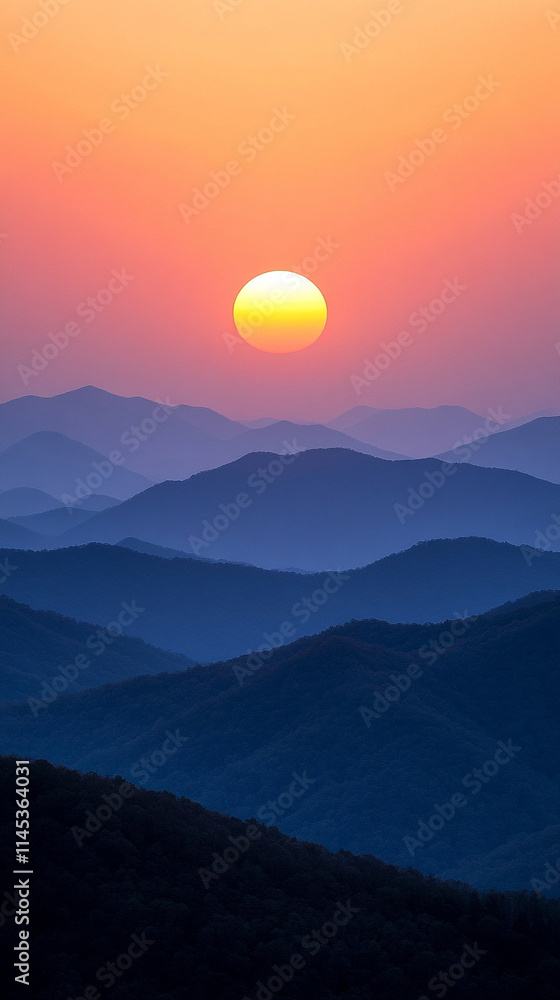 Fototapeta premium Misty mountains bathed in warm orange and yellow hues at sunset, symbolizing tranquility and the beauty of nature's chaos, a perfect high-definition phone wallpaper to evoke peace and awe