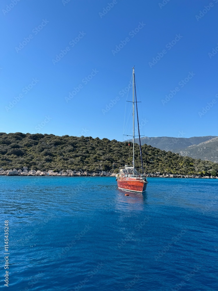 Fototapeta premium Sailing in crystal clear waters near a lush green island under a bright blue sky