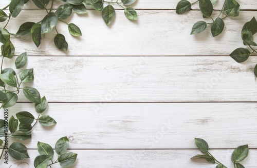 A serene arrangement of green leaves on a rustic wooden background.