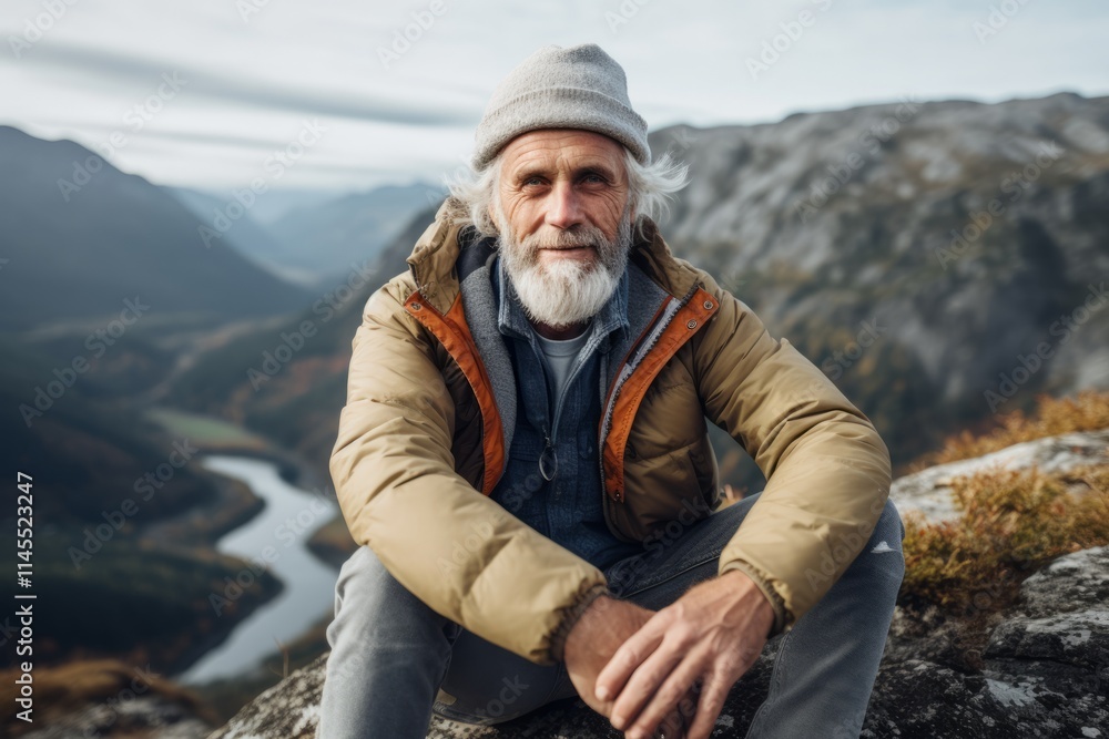 Portrait of a senior man sitting on top of a mountain and looking at the camera. Portrait of a senior man sitting on top of a mountain and looking at the camera.
