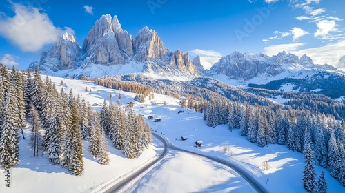 top-down aerial picture of a road, trees, and snow-covered mountains. Dolomites, Italy. 