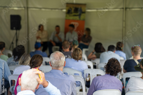 group of farmers at a field day learning about farm community  wearing a hat being sun smart. studying crops in a field, studying a soil and animals photo