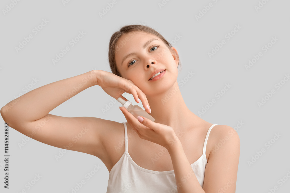 Pretty young woman with cosmetic oil on light background Pretty young woman with cosmetic oil on light background