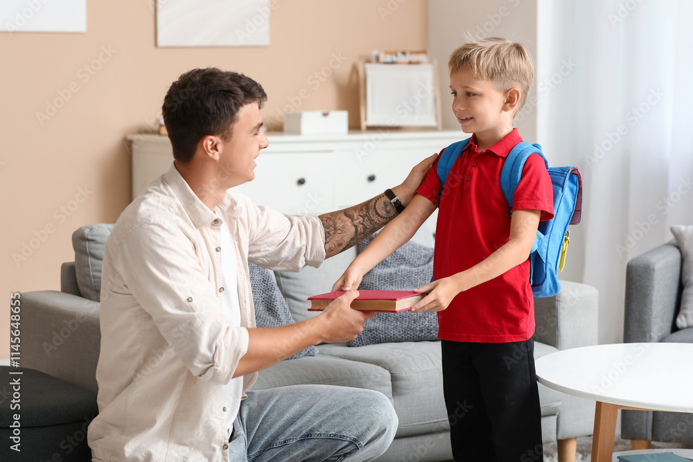 Obraz premium Father giving books to his little son at home