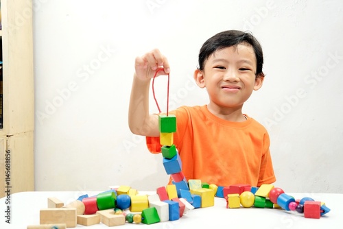 фотографія A young boy intently threads colorful wooden beads, developing fine motor skills and creativity