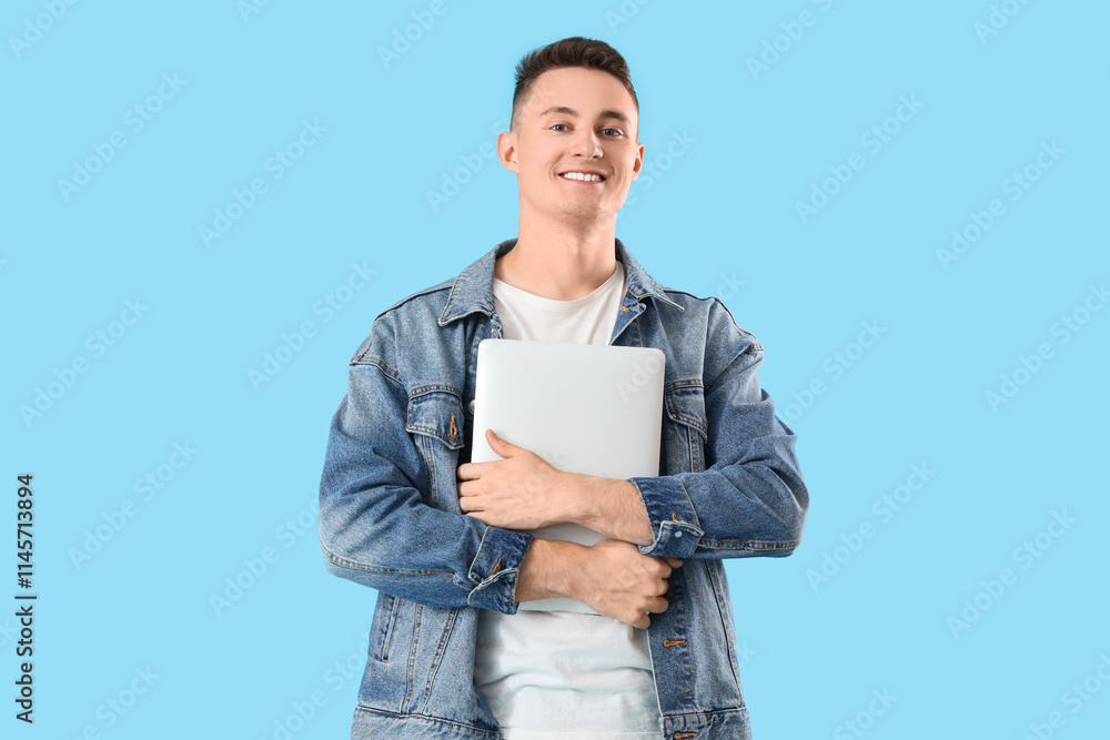 Young man with laptop on blue background Young man with laptop on blue background