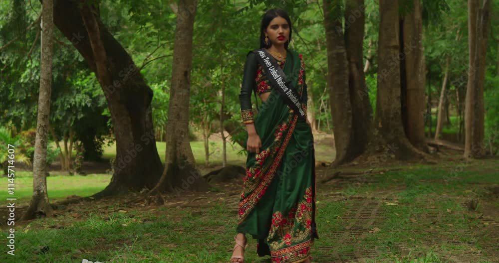 A young girl, dressed in traditional Indian attire, savors her day at a lush tropical park in the Caribbean. A young girl, dressed in traditional Indian attire, savors her day at a lush tropical park in the Caribbean.