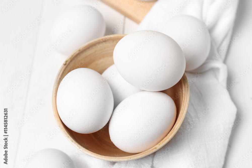 Bowl with raw chicken eggs on white wooden background Bowl with raw chicken eggs on white wooden background