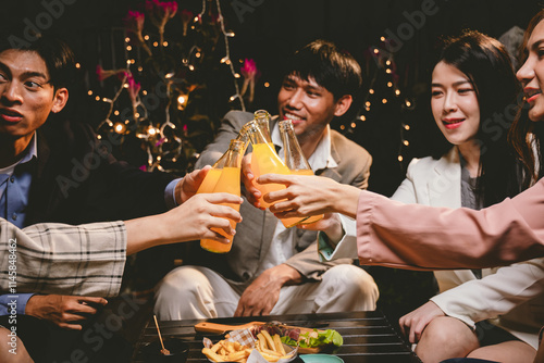 Canvas Print A lively group of friends celebrating with beer at an outdoor terrace