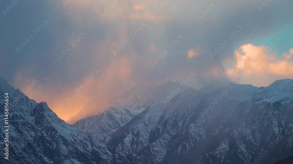 Dark stormy clouds above the snowy Himalayan mountain peaks during sunset in winter season as seen from Gondhla village in Lahaul and Spiti district, Himachal Pradesh, India. Winter sunset background.