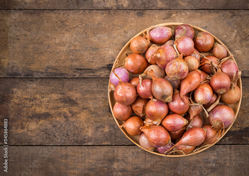 Shallots in a wood bowl on wooden background. selective focus