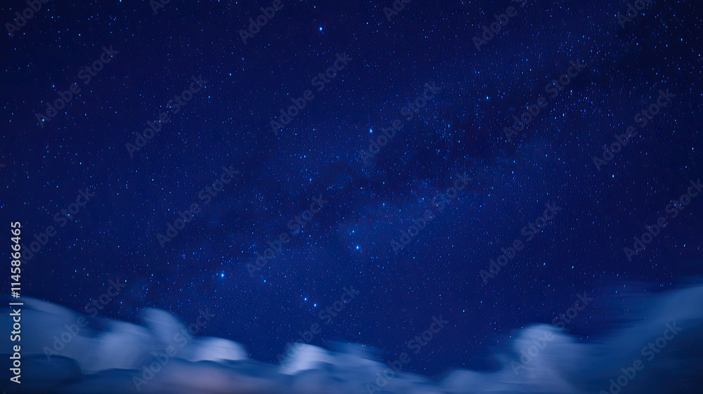 Fototapeta premium Vast Star-Studded Night Sky with Deep Blue Hue, Bright and Luminous Stars Scattered Across, Soft Fluffy Clouds at the Bottom Adding Depth and Contrast, Creating a Serene and Enchanting Nighttime Atmos
