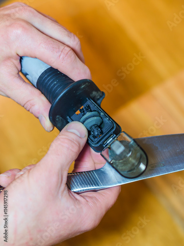 Man sharpening a knife with a handheld sharpener. High quality photo photo