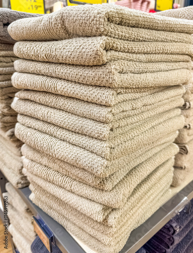 Stacks of soft, fluffy beige towels on a store shelf. High quality photo photo