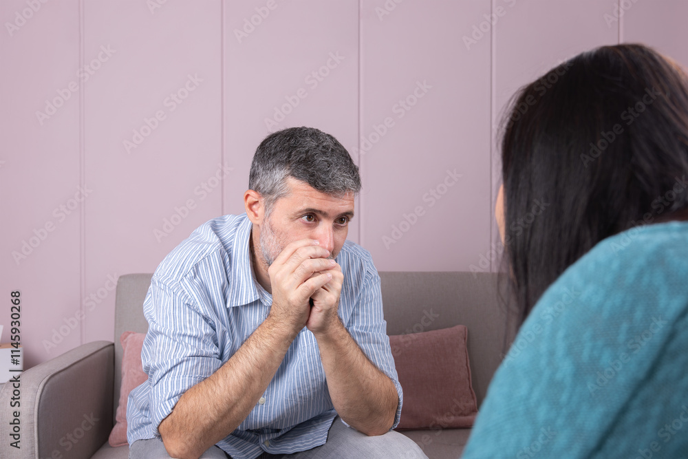 In a therapeutic consultation, a mature man reflectively observes his psychotherapist, whose figure is shown with his back turned in a serene setting. Concept of mental health and therapy In a therapeutic consultation, a mature man reflectively observes his psychotherapist, whose figure is shown with his back turned in a serene setting. Concept of mental health and therapy