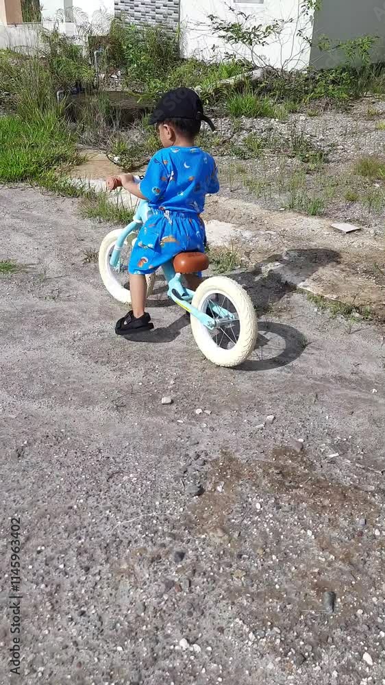 Young Boy Riding Balance Bike on Gravel Road Young Boy Riding Balance Bike on Gravel Road