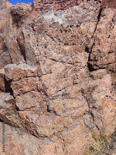 Wild red-brown rocks. Summer sunny day. Red granite in nature. Natural mineral background.