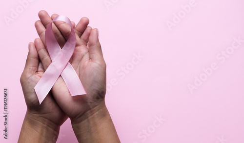 Pink Breast Cancer Awareness Ribbon. Hands holding pink ribbon on backgrounds. Breast cancer awareness and October Pink day, world cancer day. Top view. Mock up. photo