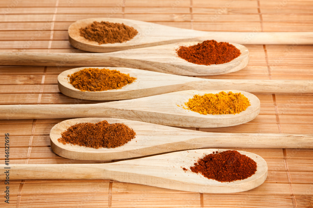 Assorted ground spices on wooden cooking spoons Assorted ground spices on wooden cooking spoons