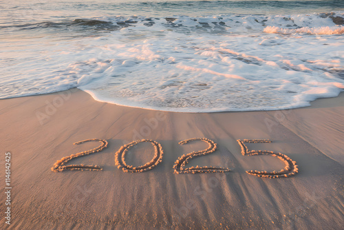 The number '2025' is written in the sand with white waves washing over the shore