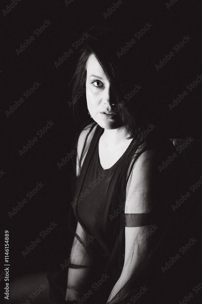 Naklejka premium Sensual portrait of a woman with dark hair, done in a low key style.