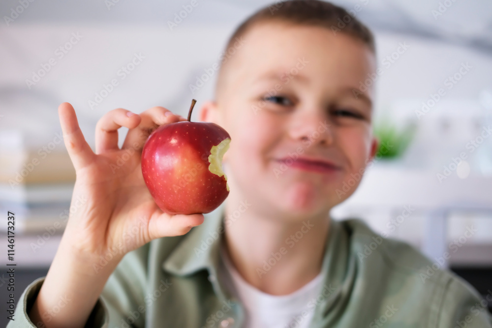 Happy boy eating an apple, face close-up. Enjoys healthy snacks, homely atmosphere, innocent look. Vitamins for whole family. Happy boy eating an apple, face close-up. Enjoys healthy snacks, homely atmosphere, innocent look. Vitamins for whole family.