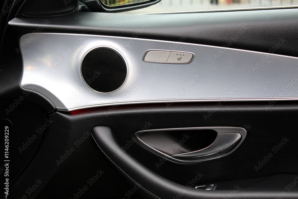Fototapeta premium Lux Passenger door interior door handle. Door handle with window control. Car interior details. Modern car interior. Black leather interior with door panel and windows switch buttons. 