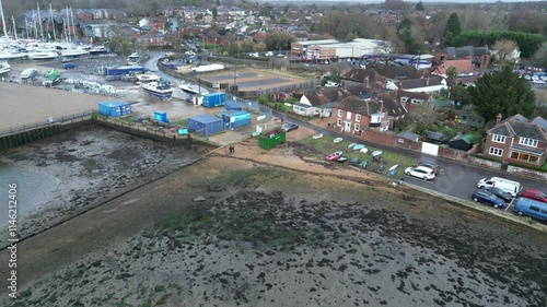 Aerial drone shot of coastal town, showcasing buildings, roads, and waterfront with calm sea, creating a scenic view of the town's layout against the natural landscape. photo