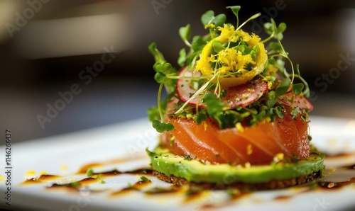 A plate of food with a piece of salmon on top of a bed of greens photo