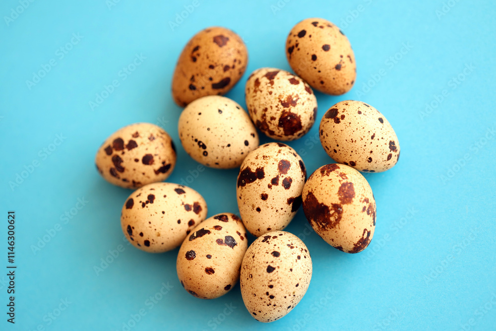 Few amount of quail eggs in small pile on blue background Few amount of quail eggs in small pile on blue background