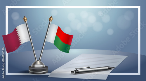 Qatar and Madagascar National flags on small table with bokeh background, cooperative relationship