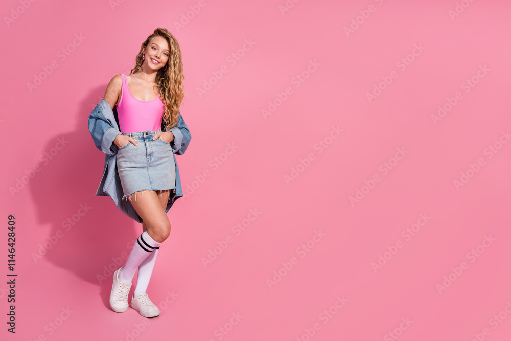 Stylish young woman standing against a cheerful pink backdrop Fashionable denim and vibrant outfit Stylish young woman standing against a cheerful pink backdrop Fashionable denim and vibrant outfit